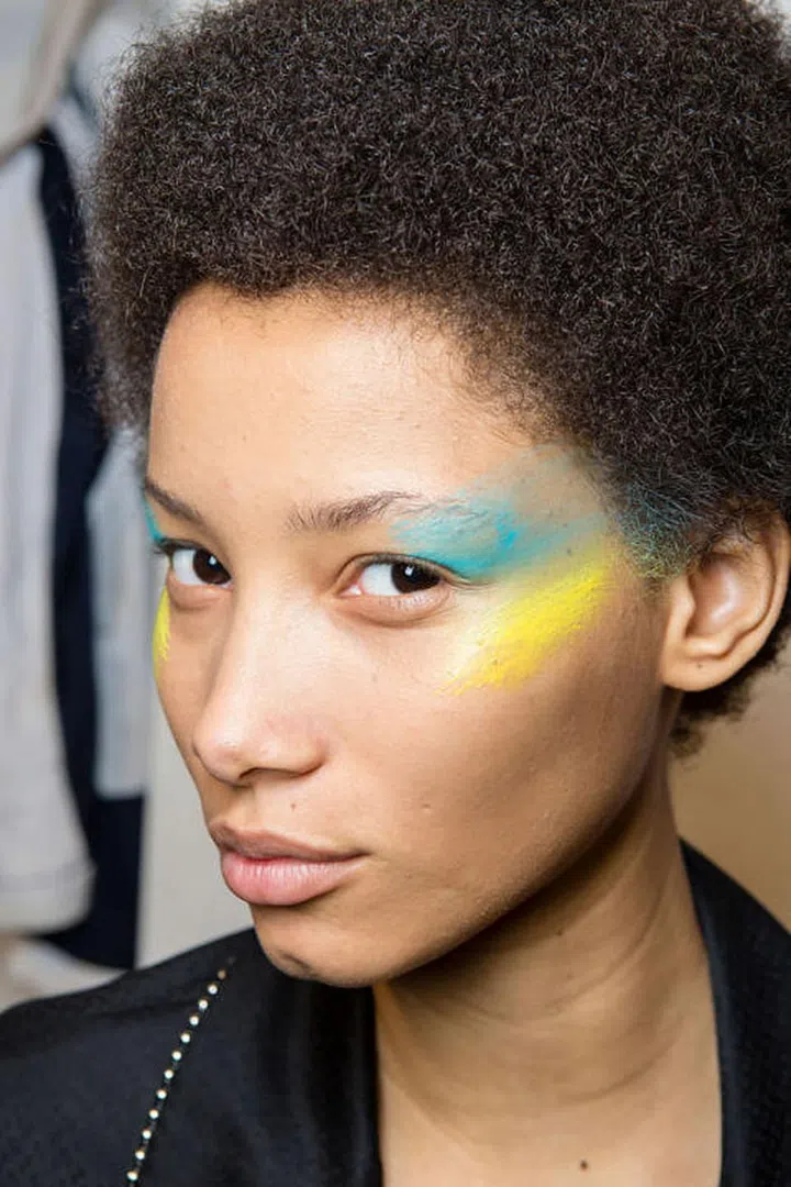 Models walked the runway with varying stripes of colored pigment dashed across their cheekbones at Max Mara.