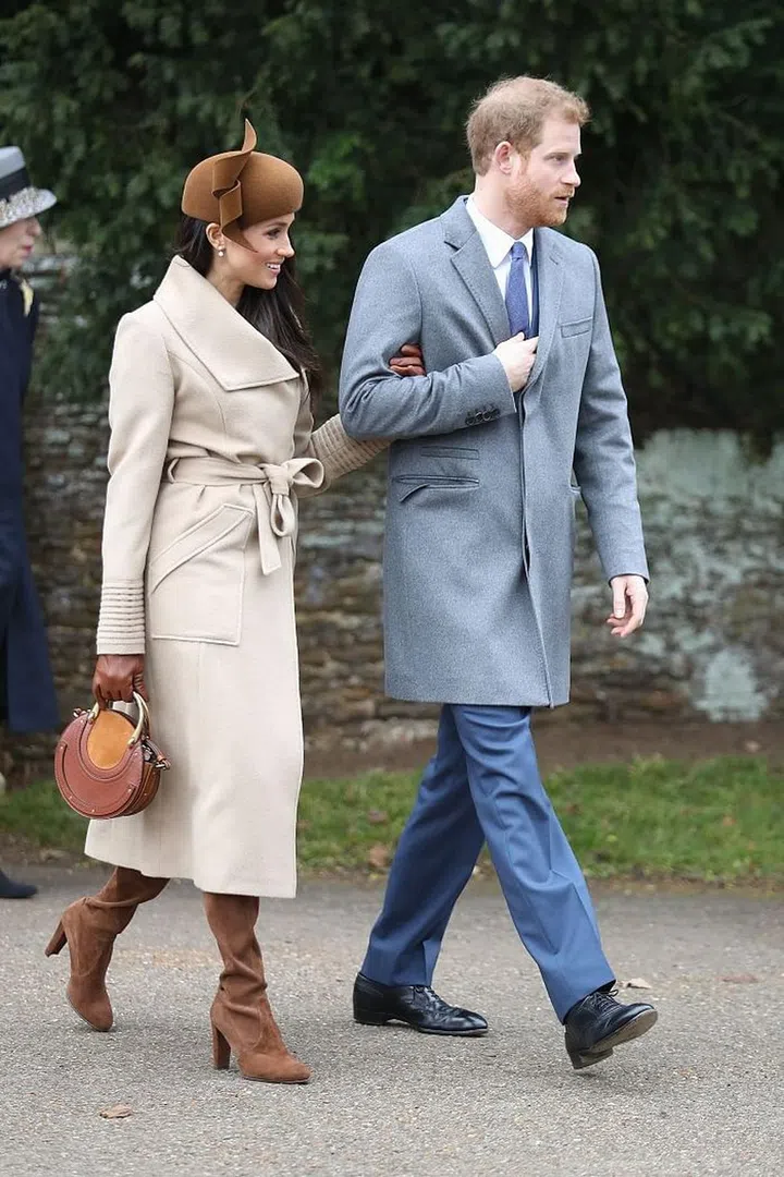 Meghan Markle wore a camel Sentaler coat with brown hat, suede Stuart Weitzman boots and a Chloé Pixie bag, while Prince Harry teamed his blue suit with a grey coat. Photo: Getty 