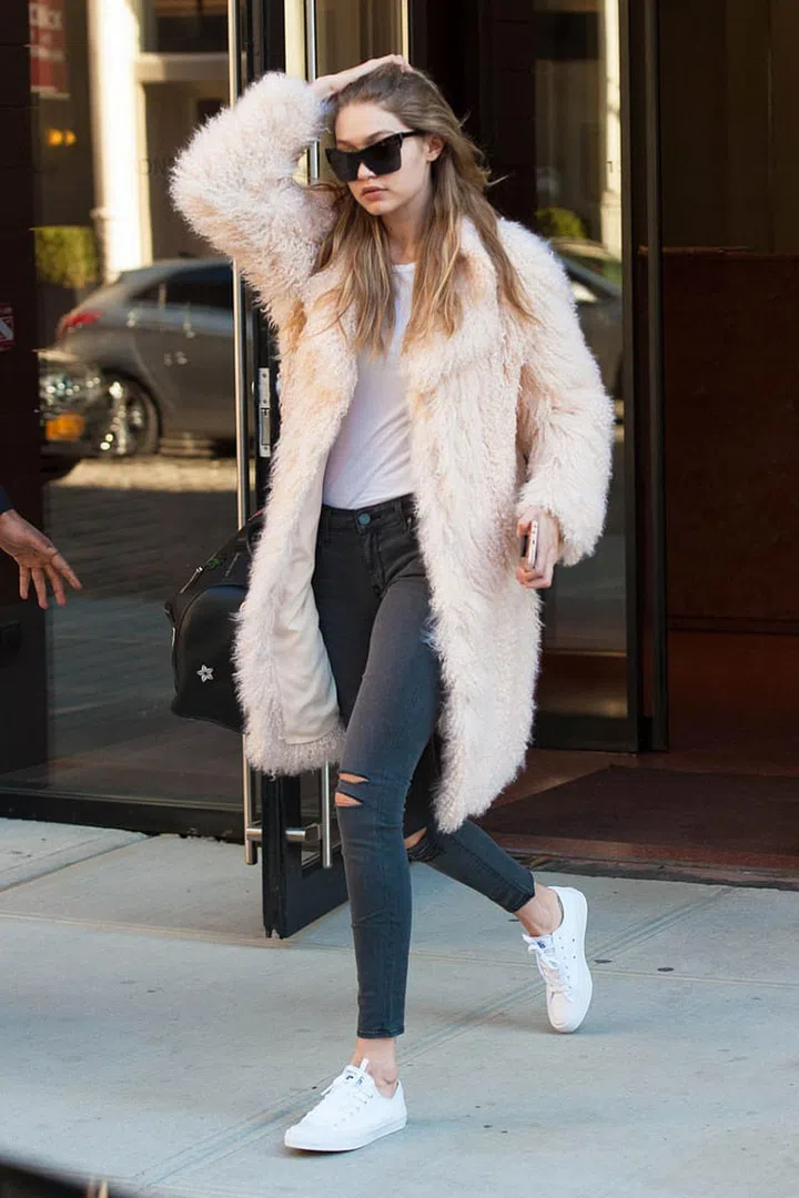 Out in New York City wearing a pale pink faux-fur coat with a white tee and distressed Parker Smith jeans, plus Converse sneakers and Elizabeth and James sunglasses. Photo: Splash