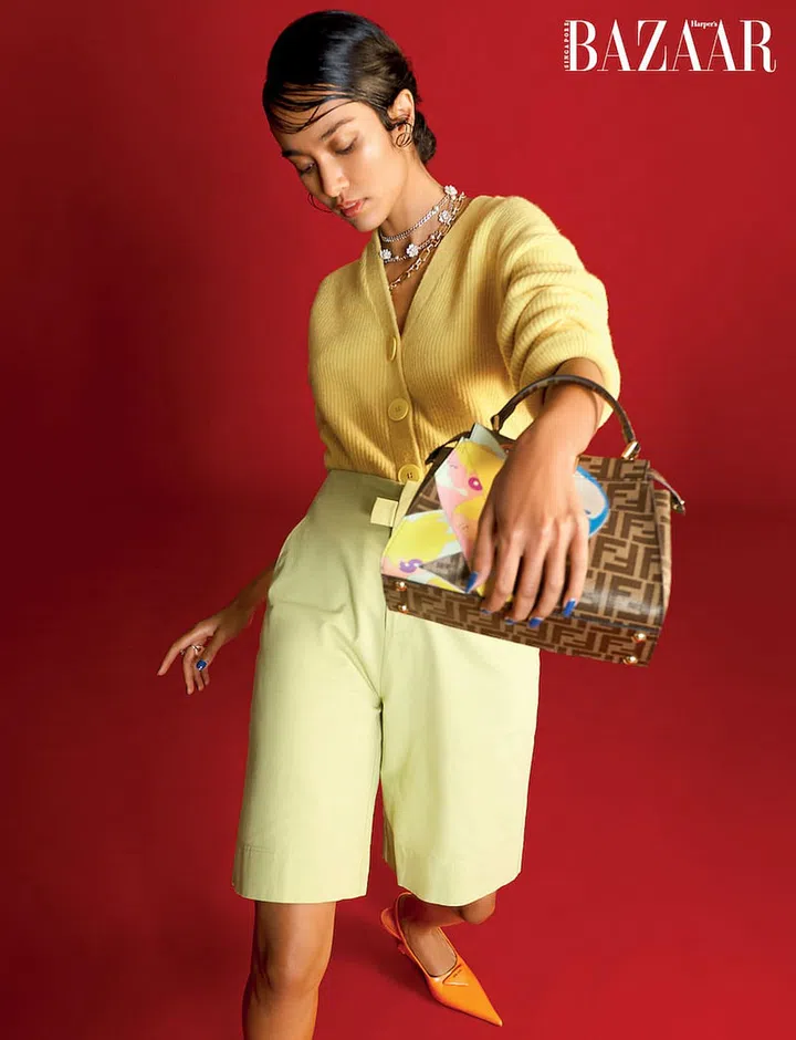 Bermuda shorts, Rye. Cardigan; necklace, Kate Spade New York. Belt (worn double looped around the neck as a necklace), Roger Vivier. Bag, Fendi. Ring, Swarovski. Slingback, Prada (Photo: Phyllicia Wang)