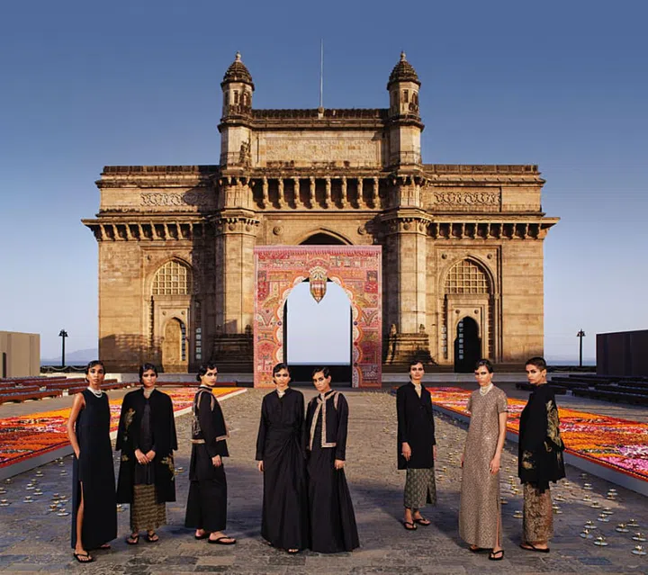 Models, striking in black and gold, against the Gateway of India