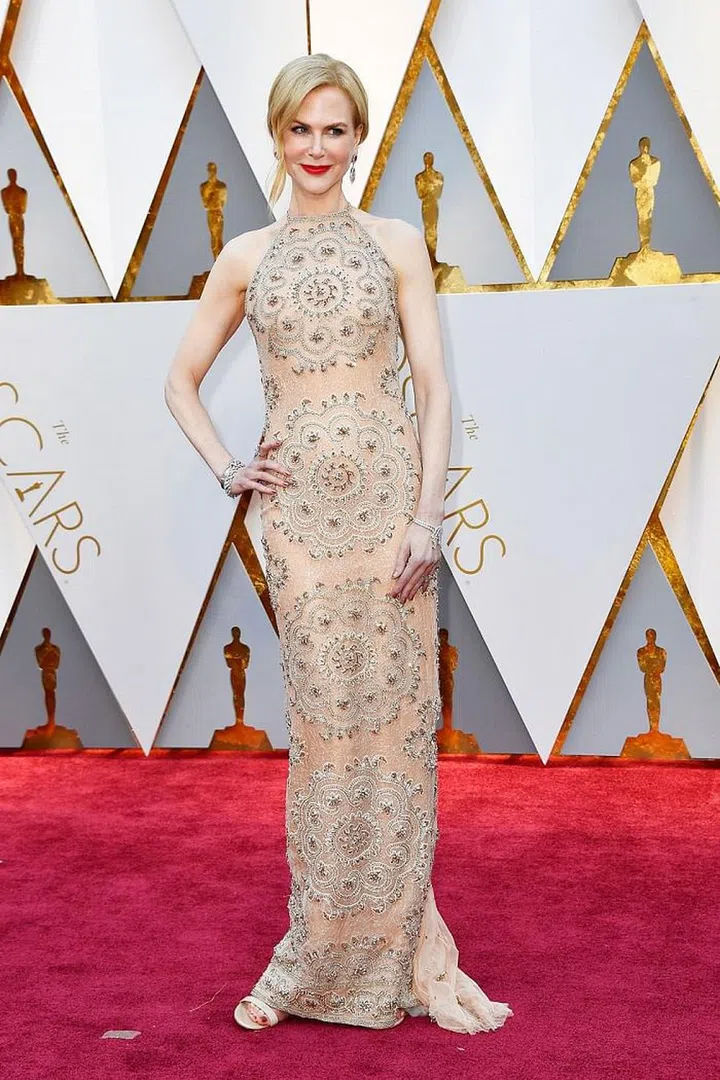 Nicole Kidman looked effortlessly long and lean in a sleek Armani Prive halter neck gown on the Oscars red carpet. Her decision to pair the champagne look with a bold red lip and ruby earrings by Harry Winston made the look her own (and paired well with her strawberry with blond locks).