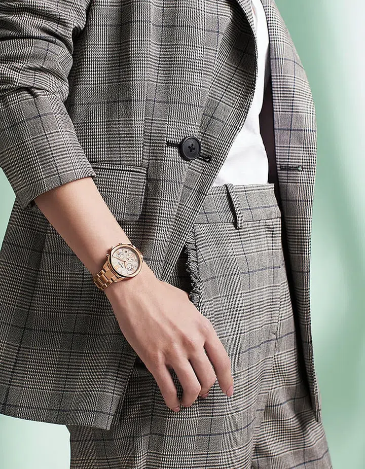 Rose gold PVD steel Lukia Chronograph watch, Seiko. Jacket; pants, Kate Spade New York. Shirt, stylist’s own.