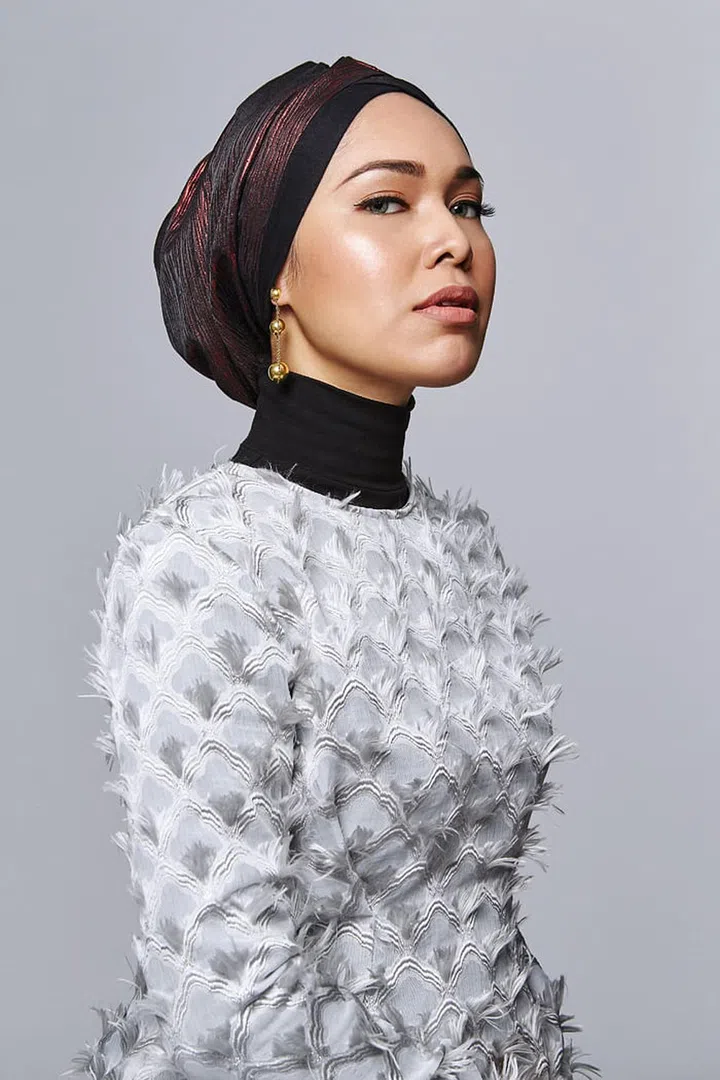 Anis wears her own Adlina
Anis turban, turtleneck
sweater and top. Gold HardWear Triple Drop
earring, Tiffany & Co.