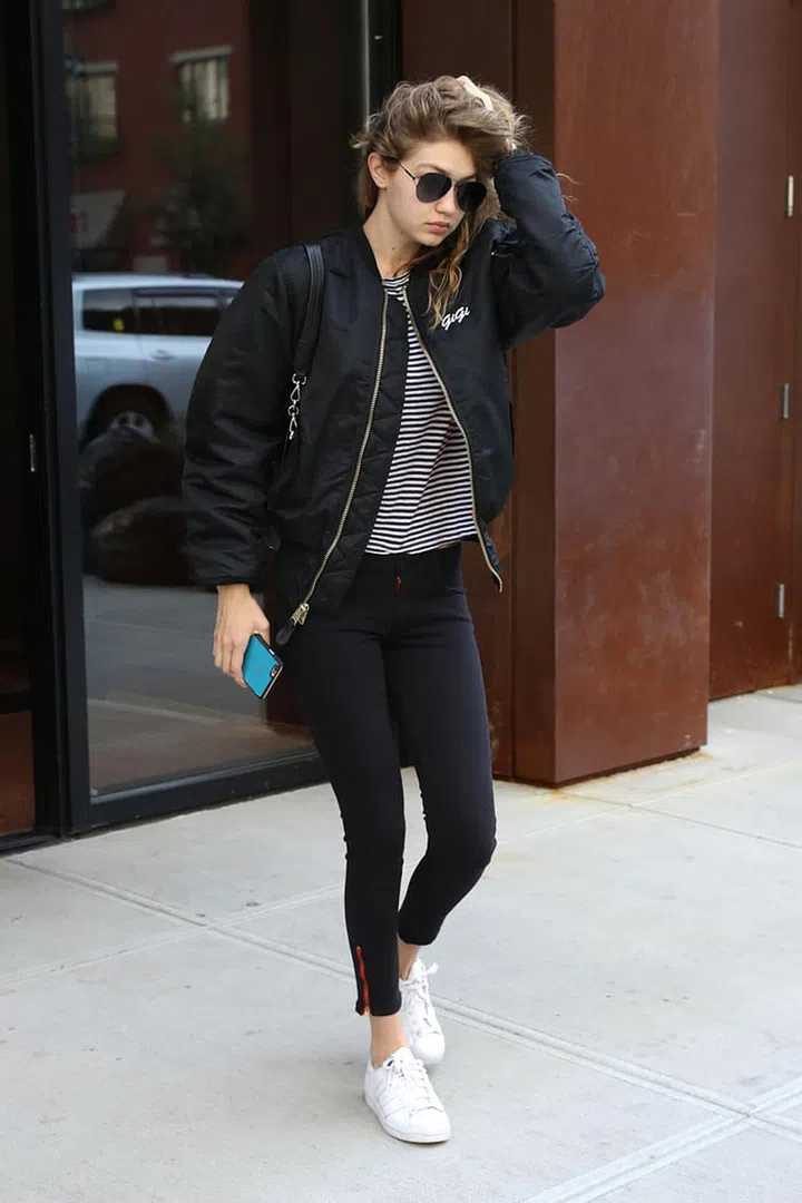 Hadid rocks her go-to athleisure look with a personalised black bomber jacket featuring a small "Gigi" logo on the chest. Photo: Splash