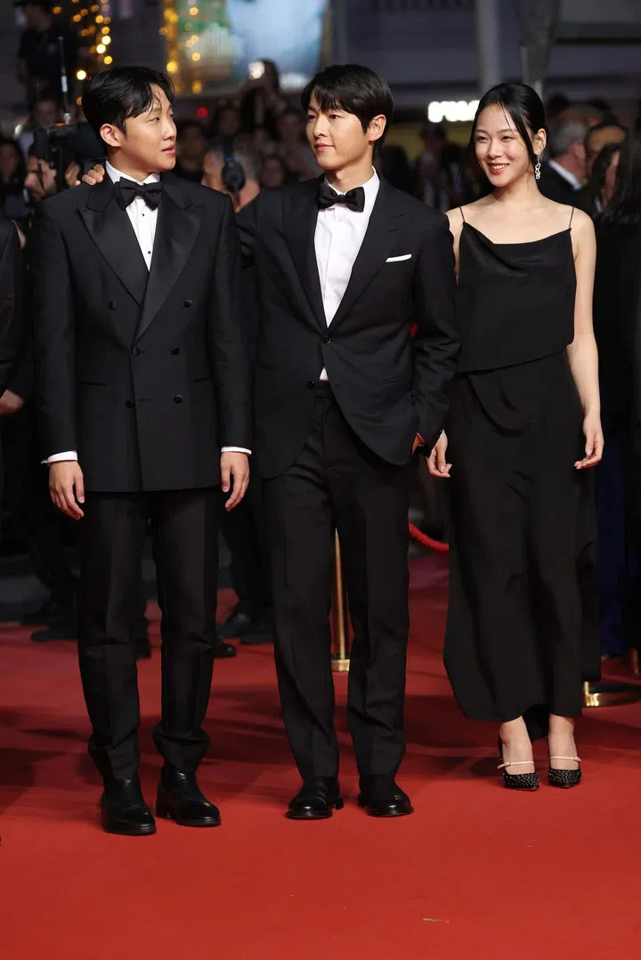 (left to right) Xa Bin Hong, Song Joong-ki and Hyoung Seo Kim at the "Il Sol Dell'Avvenire (A Brighter Tomorrow)" red carpet during the 76th annual Cannes film festival at Palais des Festivals 2023 in Cannes, France. Photo: Getty