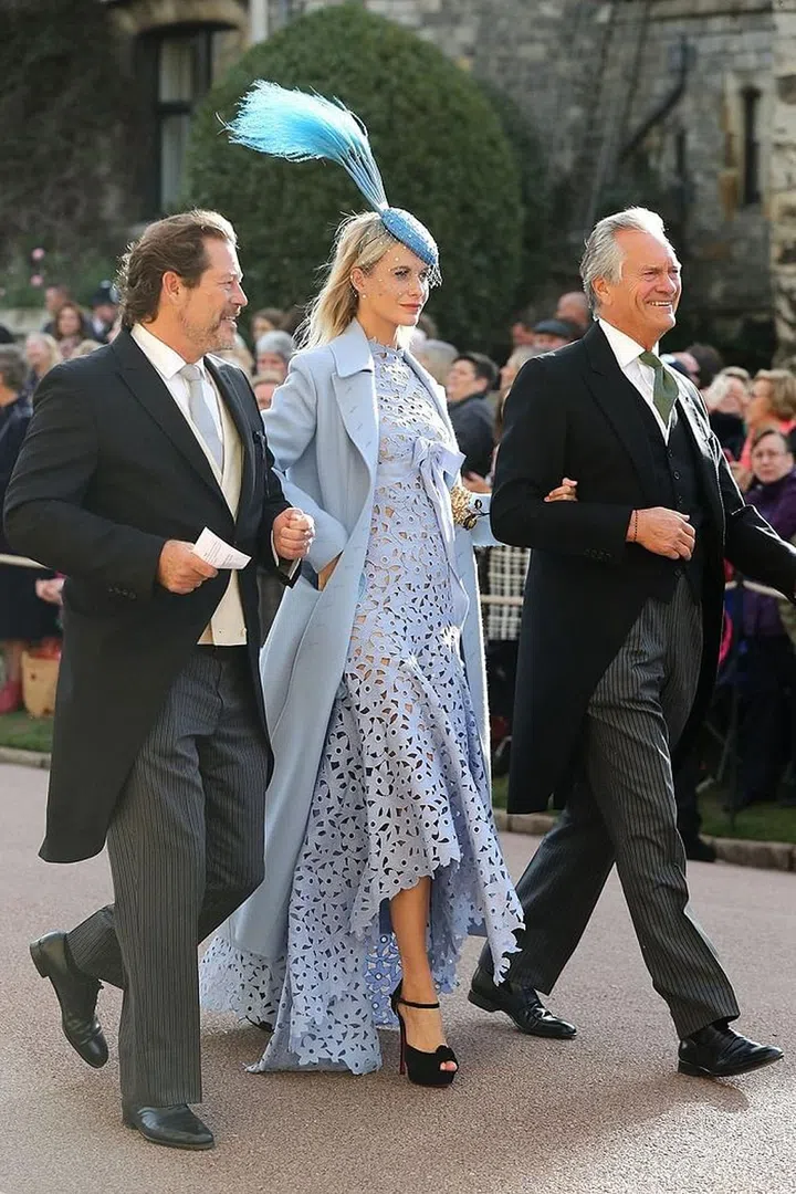 Socialite Poppy Delevingne arriving in a baby blue lace dress and sky-high feather fascinator.