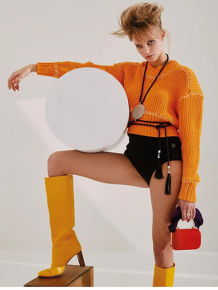 Cotton sweater, H&M. Polyamide-blend bikini bottoms, Eres. Leather and metal necklace, Longchamp. Gold-plated metal and crystal rings, Swarovski. Suede bag, Jimmy Choo. Leather Boots, Kate Spade New York.