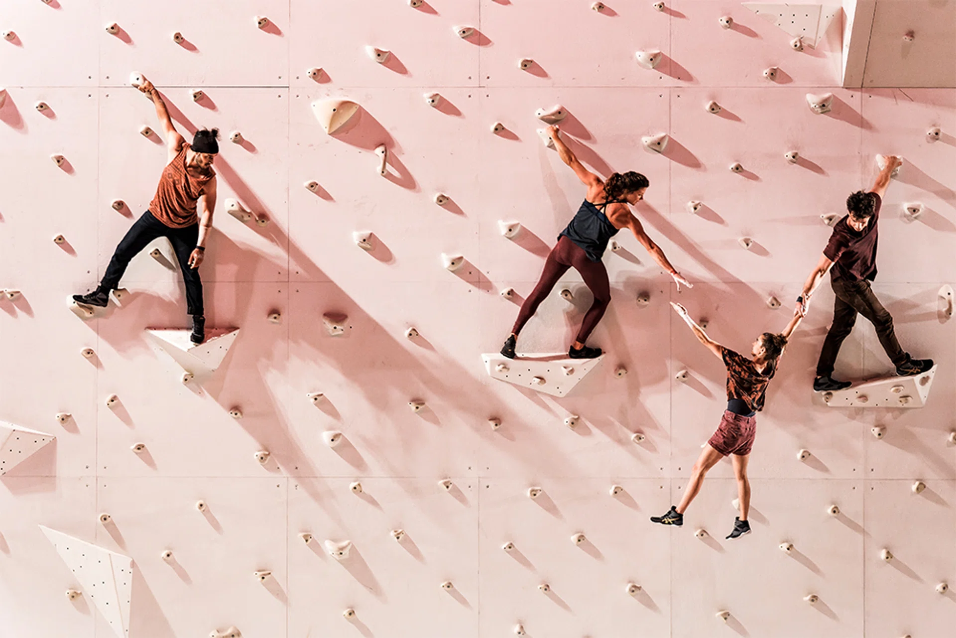corp extremes acrobats performing routine on a rock wall