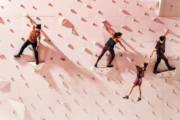 corp extremes acrobats performing routine on a rock wall