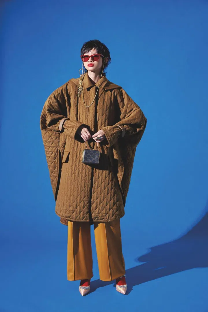 Coat, from Max Mara. Trousers, from Loro Piana. Sunglasses, and sunglasses chain, both from Gentle Monster. Ring, from Dior. Bag, from CELINE by Hedi Slimane. Heels, from Manolo Blahnik. Socks, stylist’s own. (Photo: Vee Chin)