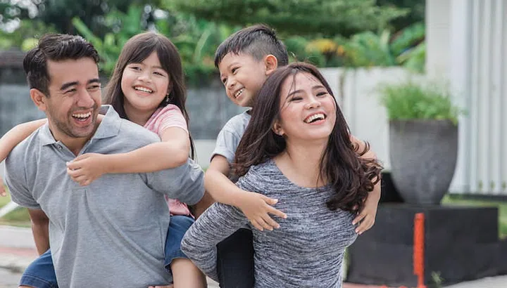 portrait of happy asian family in front of their new house