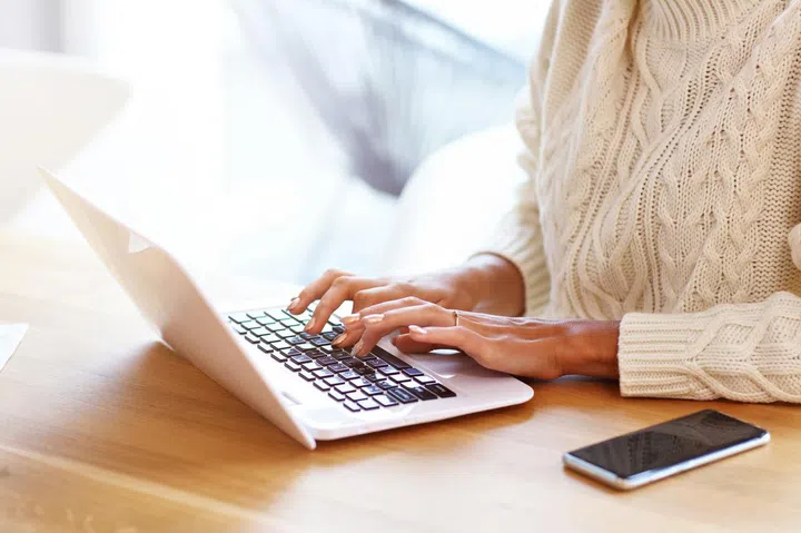 Picture of adult woman wearing warm sweater and working at home