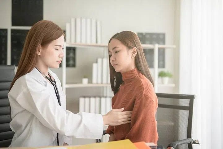 Doctor woman examining her patient breast for cancer