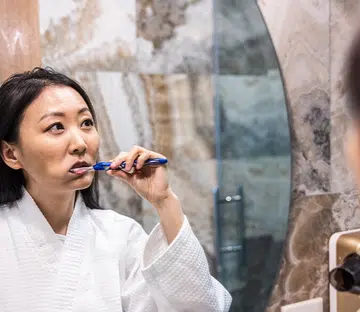 asian woman brushing teeth