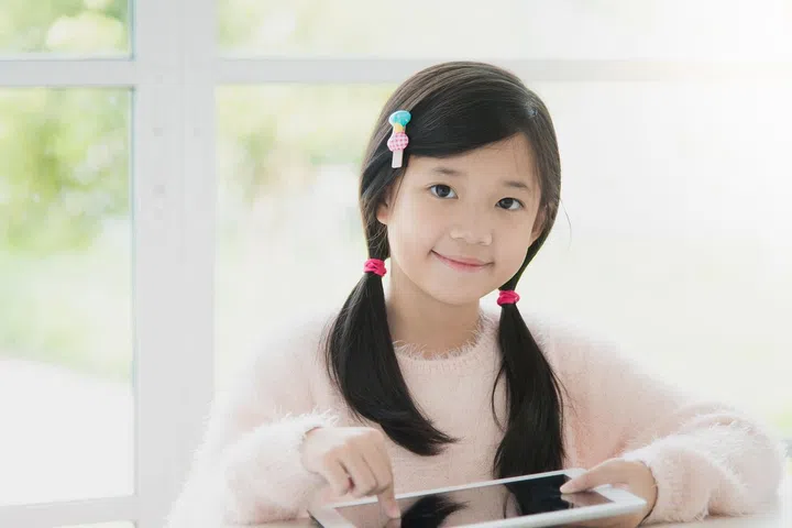 Beautiful asian girl using tablet on white table