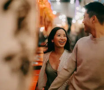 couple holding hands looking and smiling at each other | where you should travel in the year of the fire horse 
