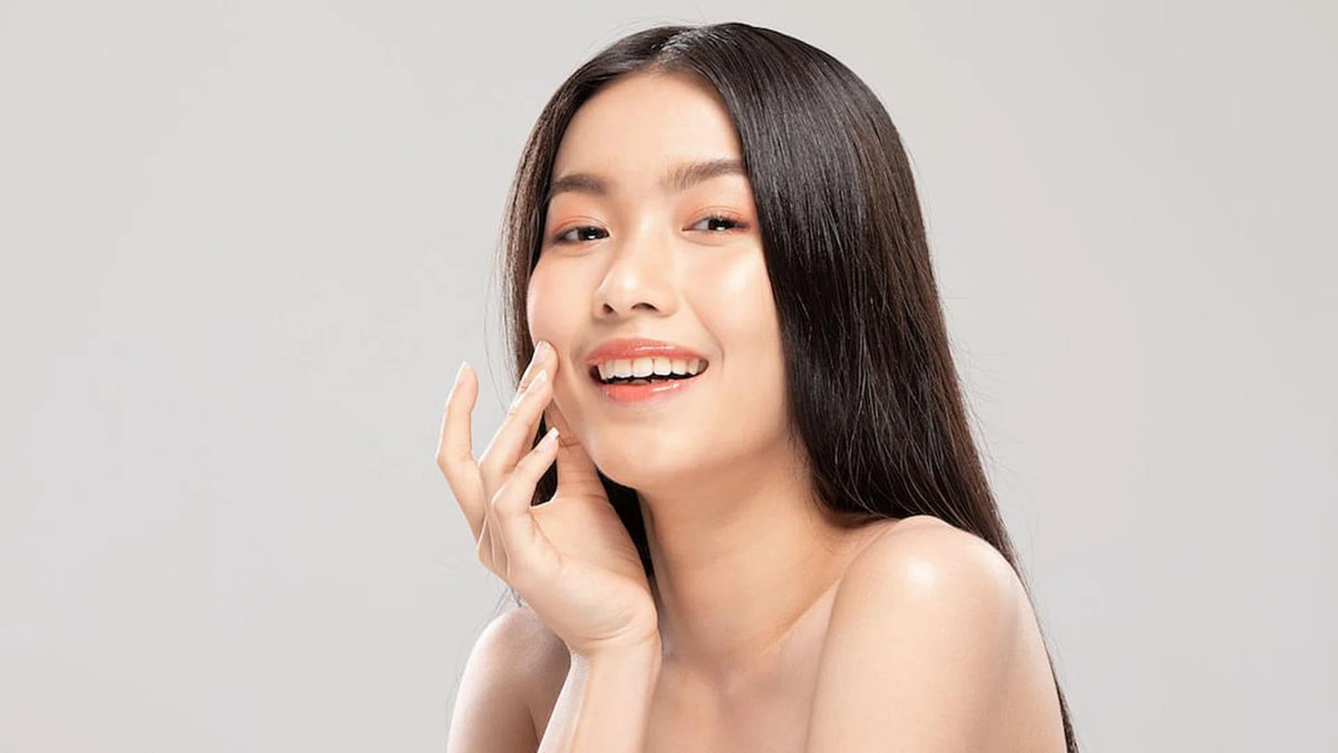 Beautiful Asian young woman touching soft cheek smile with clean and fresh skin Happiness and cheerful with positive emotional,isolated on white background,Beauty and Cosmetics Concept
