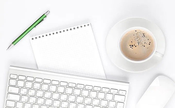 Office desk table with computer, supplies and coffee cup. Top view with copy space