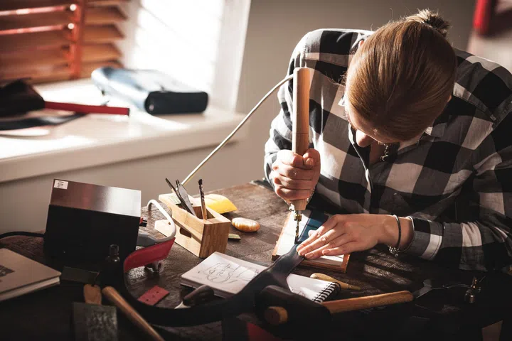 62612775 - leather handbag craftsman at work in a workshop