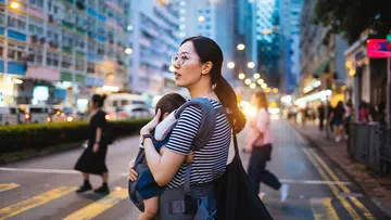 asian woman carrying child