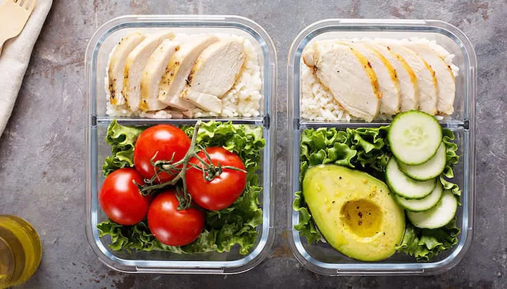 Healthy meal prep containers with chicken, rice and salad