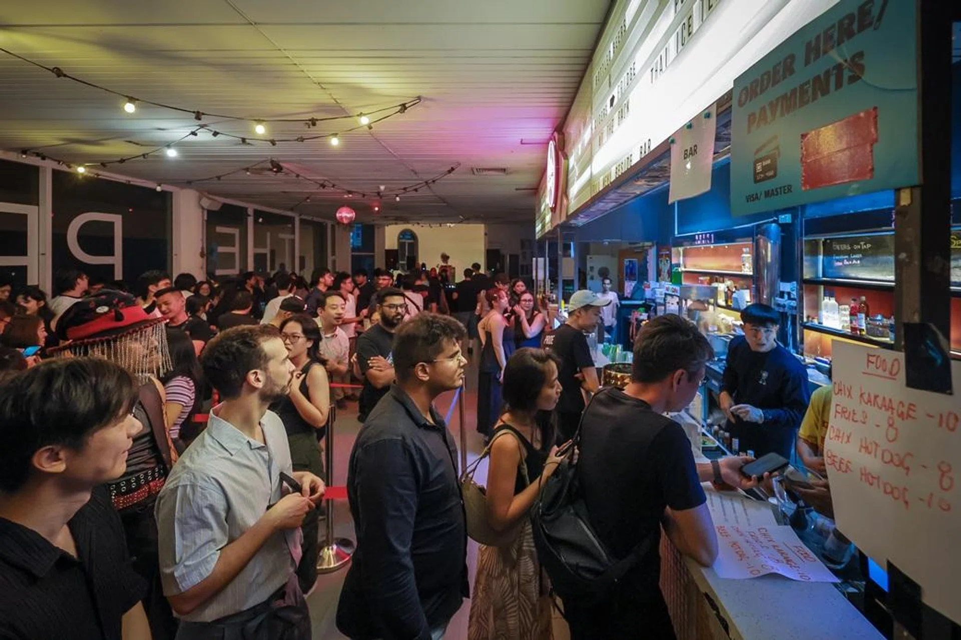 Supporters buying food at the unofficial farewell party for the indie cinema The Projector at Golden Mile Tower on Aug 23, 2025. 2025年8月23日，位于黄金大厦（Golden Mile Tower）的The Projector影院熄灯前，不少电影发烧友前往道别。