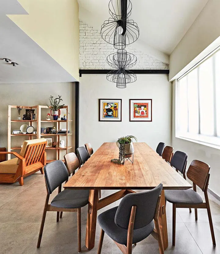 The wishbone legs make for an interesting detail in this 12-seater dining table fabricated using wood upcycled from a railway track.