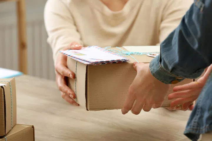Woman gives parcel in post office