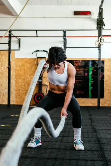 Athletic Woman Training With Battle Ropes In A gym Box