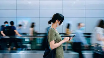 woman using phone in the middle of walkway