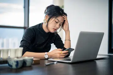 A young Asian white-collar woman looks tired in the office