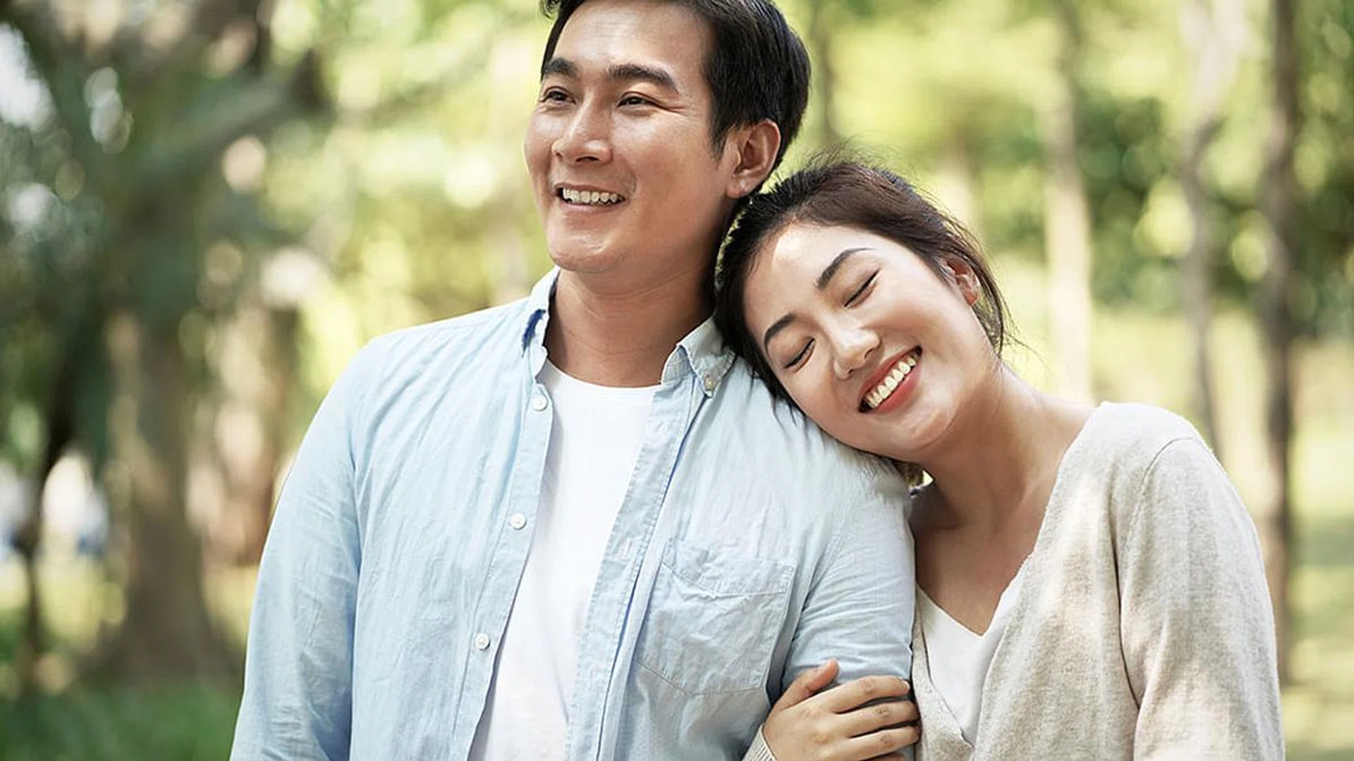 happy loving young asian couple relaxing in park