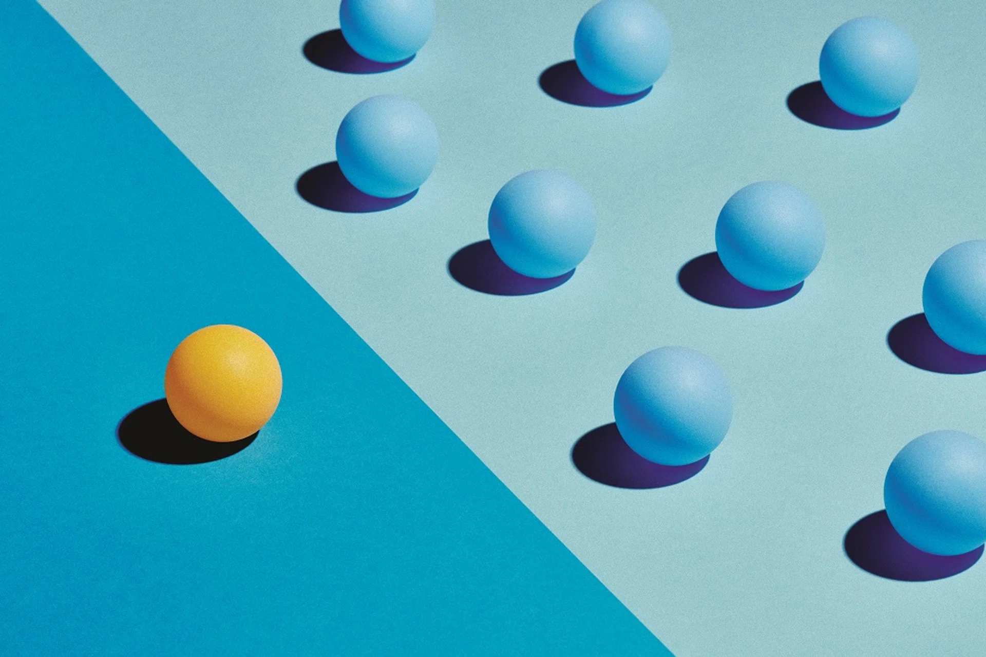 A Yellow sphere sits apart from a group of blue spheres. They are divided by differently coloured areas