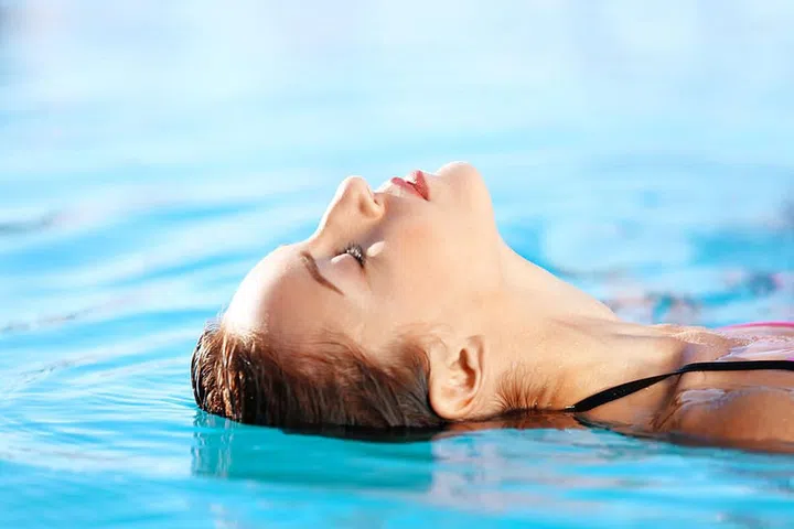 Portrait of beautiful young woman in swimming pool