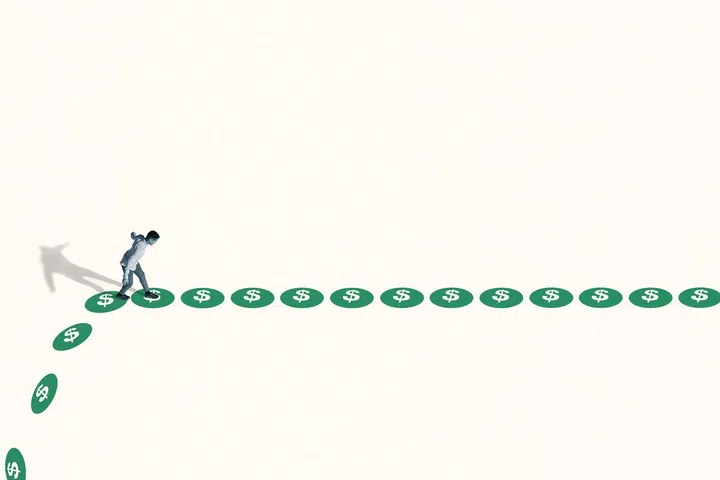 High angle side view of watchful young man walking on green dollar signs against white background