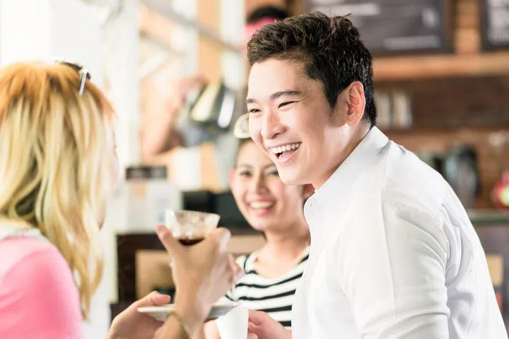People having coffee and fun in Asian cafe drinking espresso