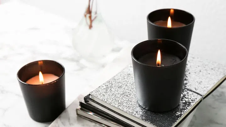 Burning candles and notebooks on table, space for text