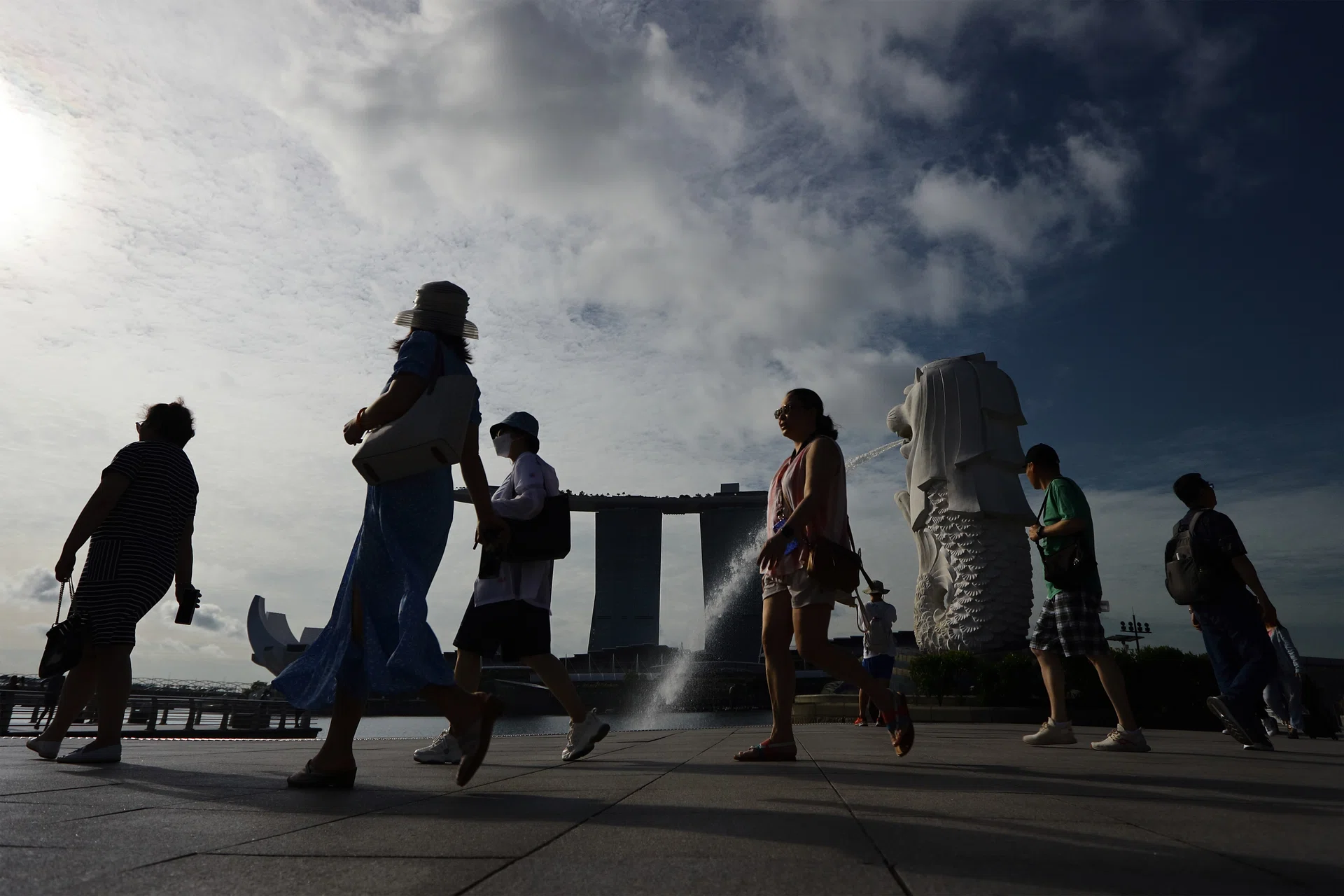Tourists are pictured against the ArtScience Museum, Marina Bay Sands and Merlion on May 10, 2023 in Singapore.
 (Photo by Suhaimi Abdullah/NurPhoto via Getty Images)