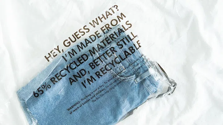 blue jeans in plastic bag with tag recycled materials and recyclable. zero waste concept