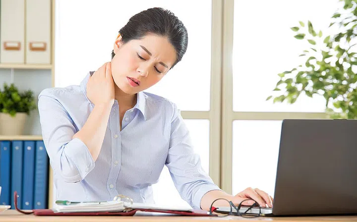Young asian business woman with pain in neck in office