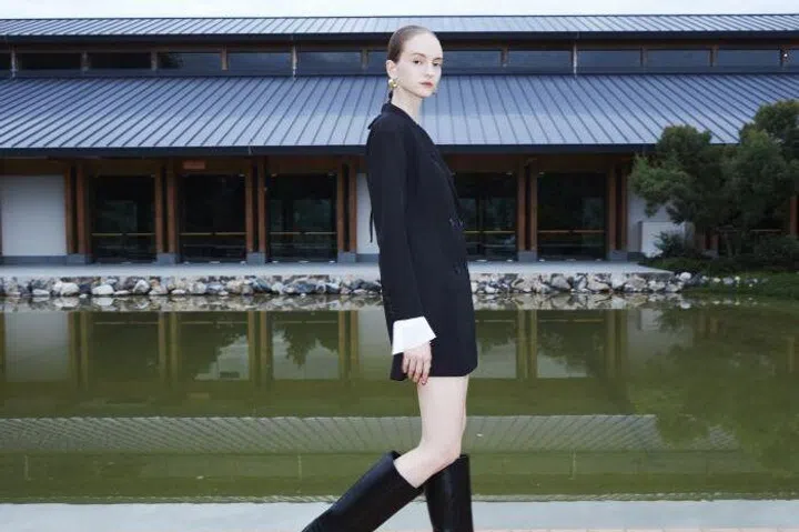 Caucasian woman wearing black and white clothes and black boots from GG<5