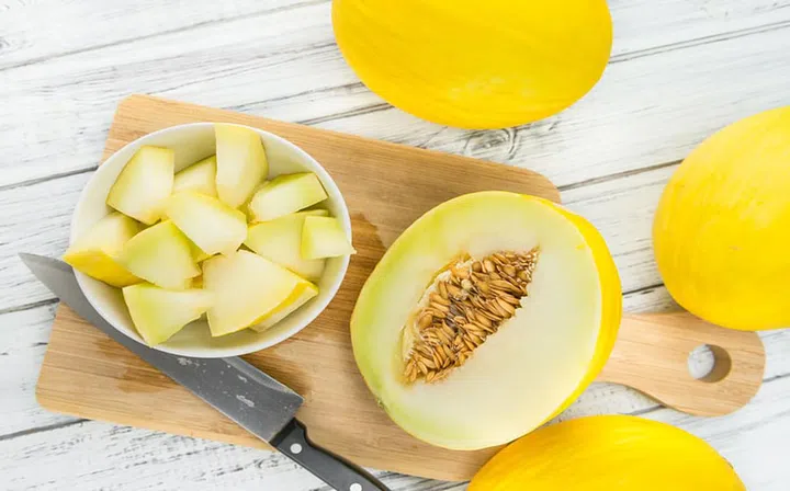 Fresh made Yellow Honeydew Melon on a vintage background (close-up shot)