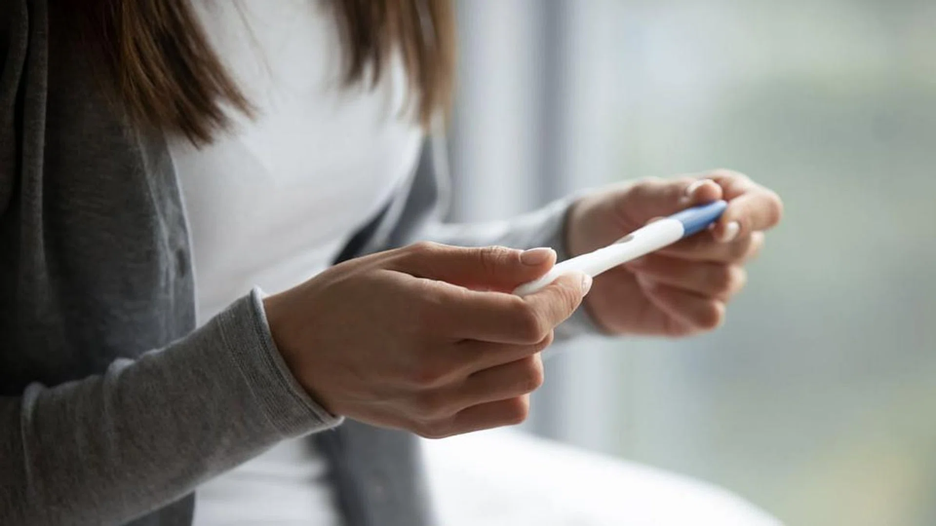 woman holding a pregnancy test