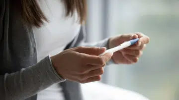 woman holding a pregnancy test