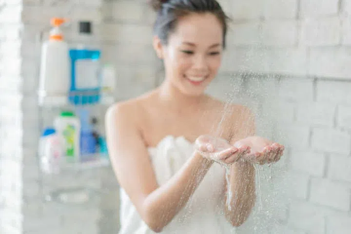 Asian women are taking a shower in the bathroom she is rubbing soap,she is happy and relaxed.