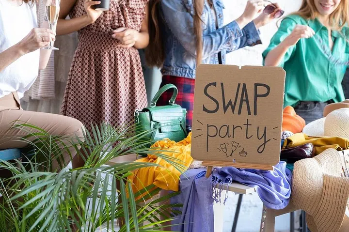 Young women at swap party. Casual clothes, shoes, hats, bags, jewellery. Idea of exchange your old wardrobe for new. Eco friendly cloth concept. Zero waste shopping, reduce and reuse, donation