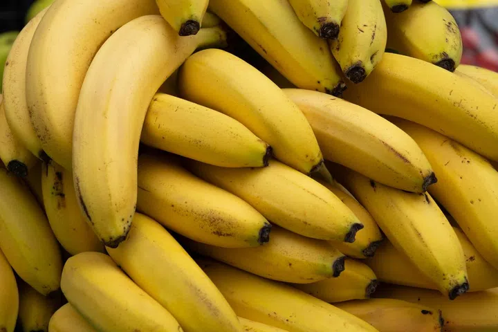 Ripe yellow bananas at the shopping market. Fruits that are good for health. The concept of vegetarianism, veganism and raw food. Vegetarian, vegan and raw food and diet. Food background, bright color. Retail sale of seasonal products.
