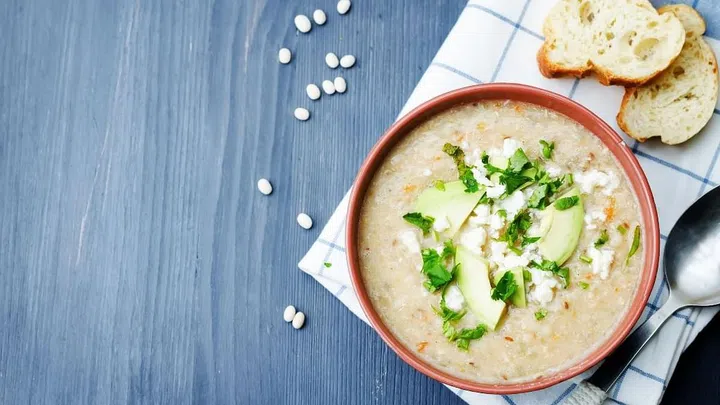 White beans chicken soup on a dark wood background. toning. selective focus