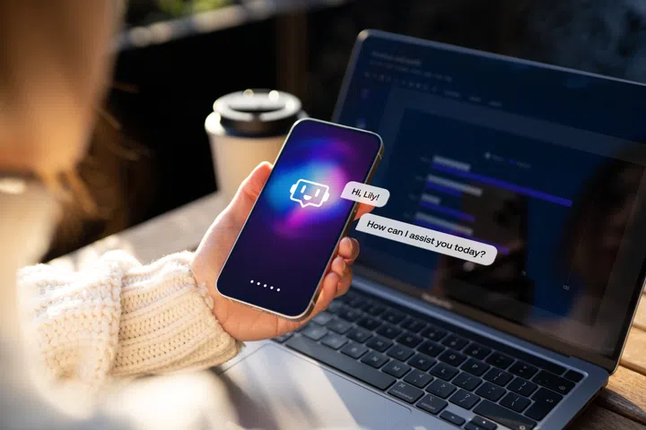 Female hand holding smartphone showing chatbot conversation with virtual assistance app. Open AI technology. Online robot system.